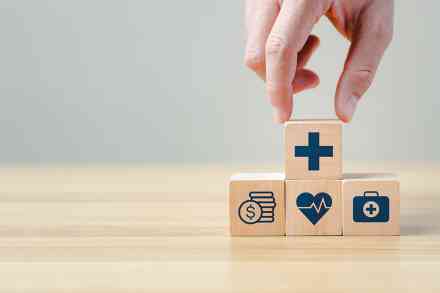 Hand legt einen Holzblock auf andere Blöcke